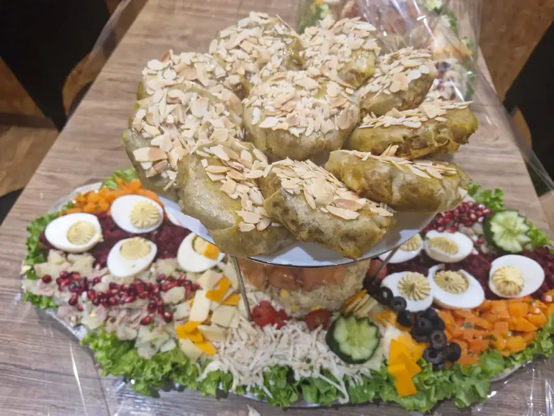 Pièce montée de pastillas aux amandes sur un grand plateau de salade composée